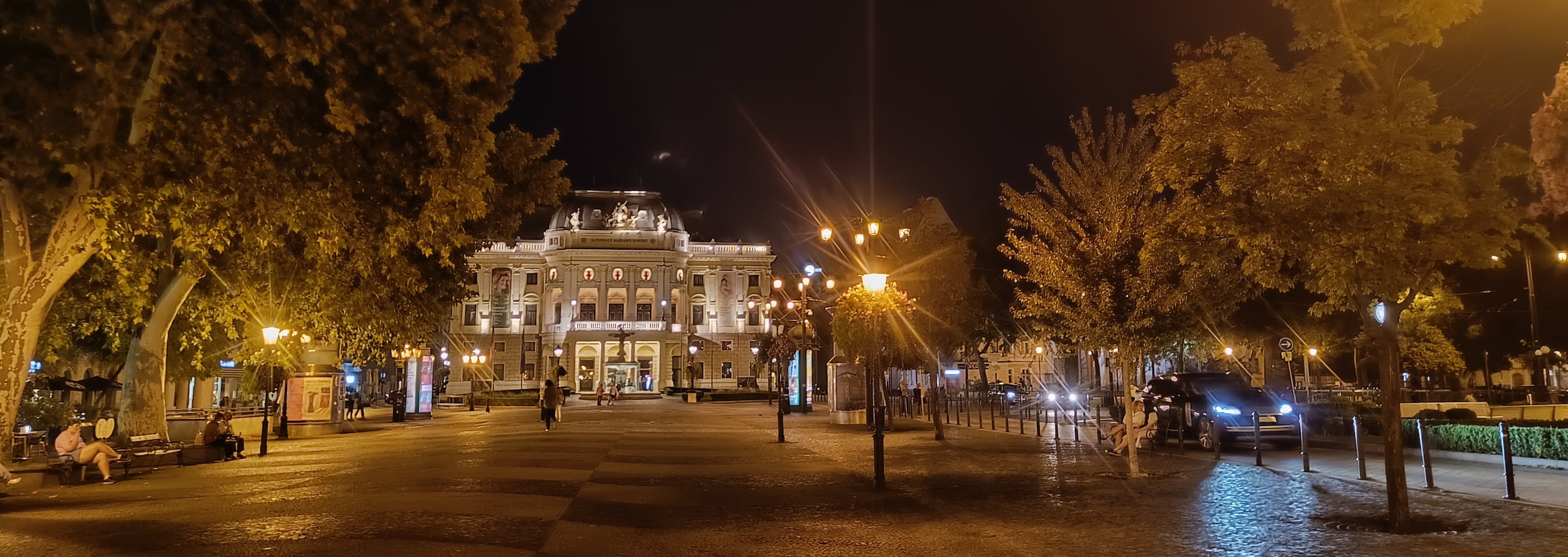Ľudovít Štúr Square at night, looking down a tree-lined promenade to the illuminated Old National Theater
