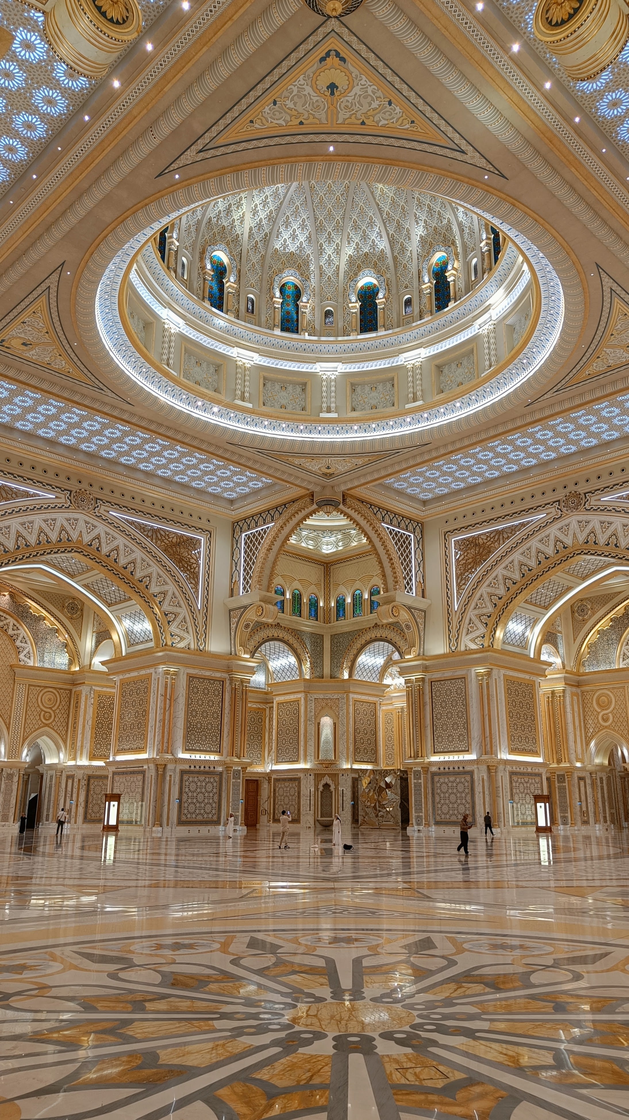 The great hall of Qasr Al Watan: a vast marble floor under a white and gold dome with stained glass and geometric ornament